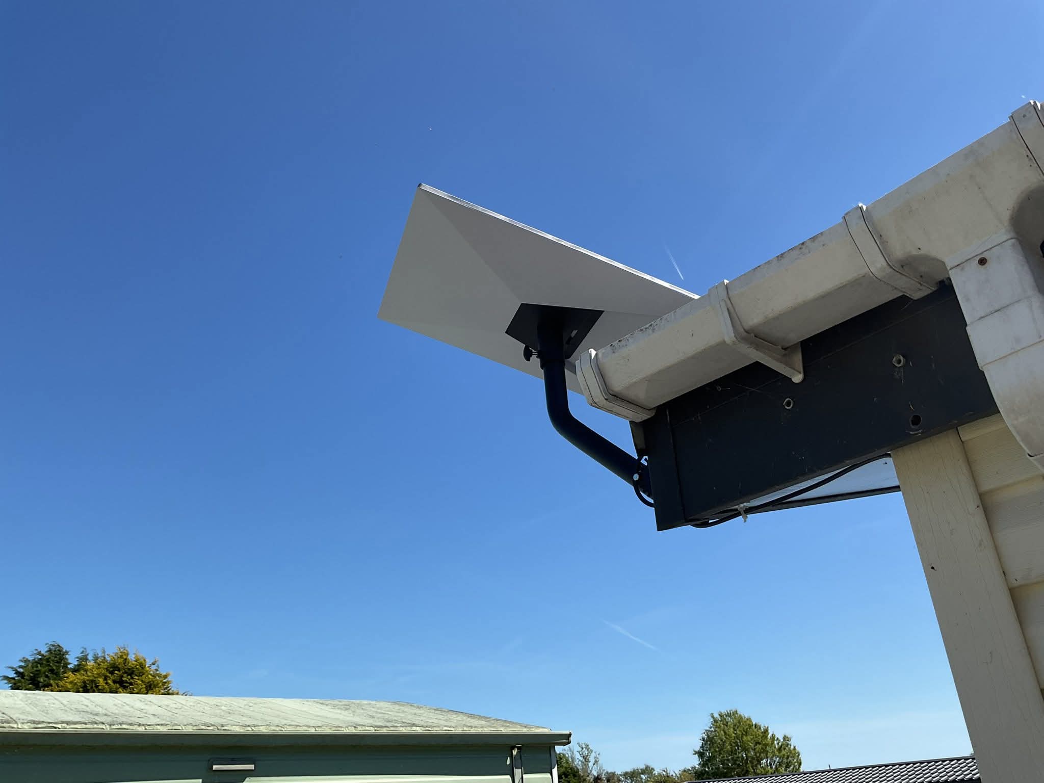 Starlink roof installation with wide blue sky