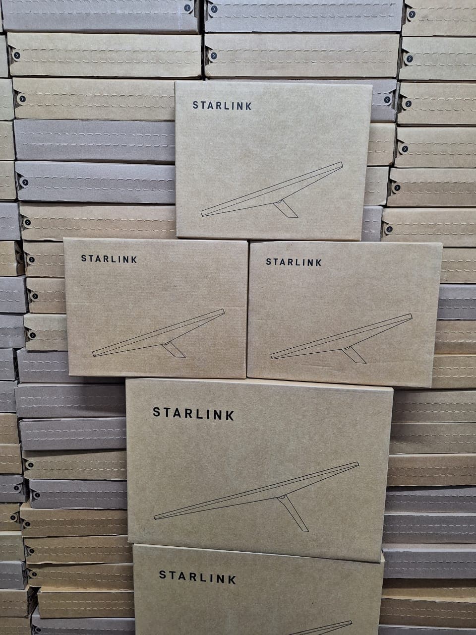 Multiple Starlink kits displayed against a stock wall
