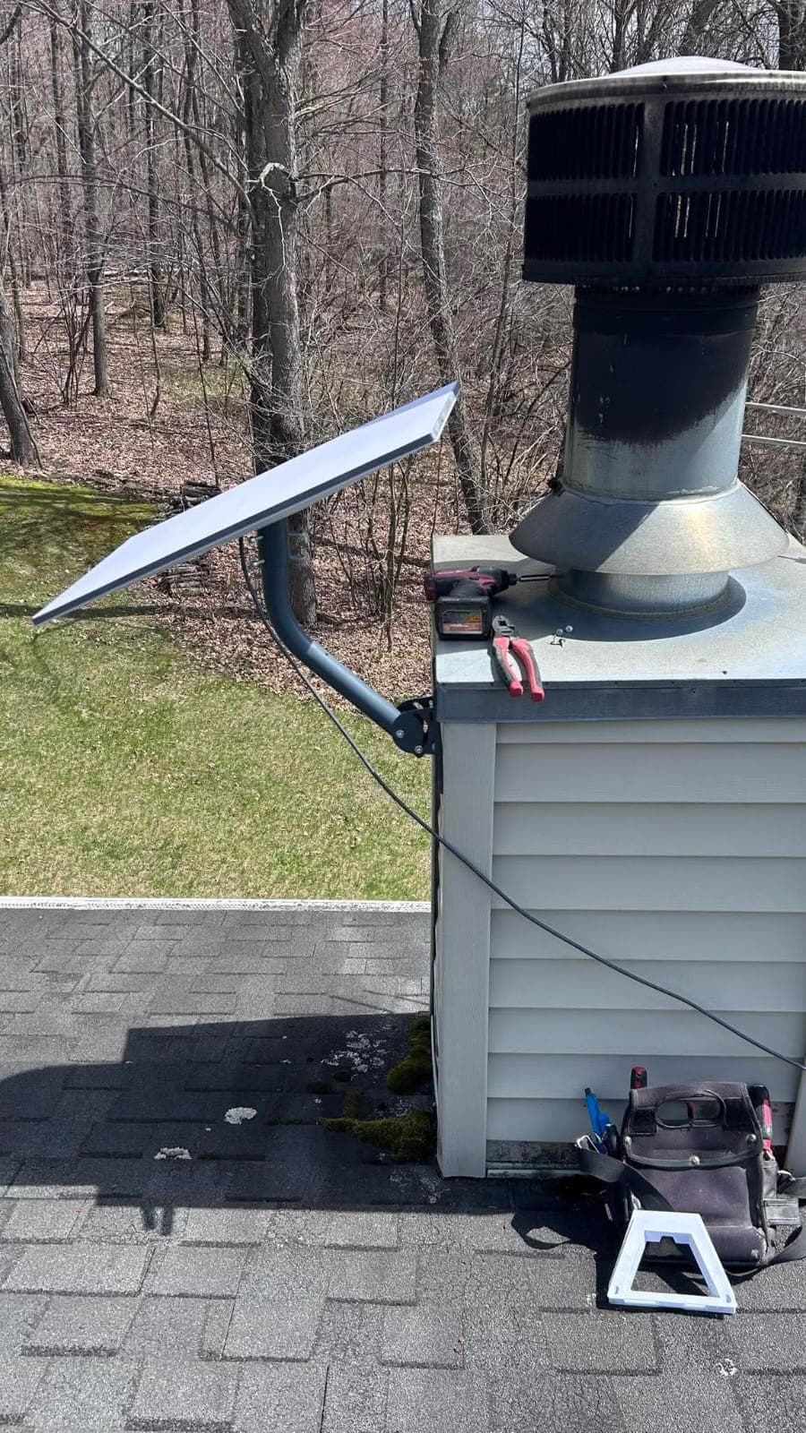 Starlink dish installed on a roof near a chimney
